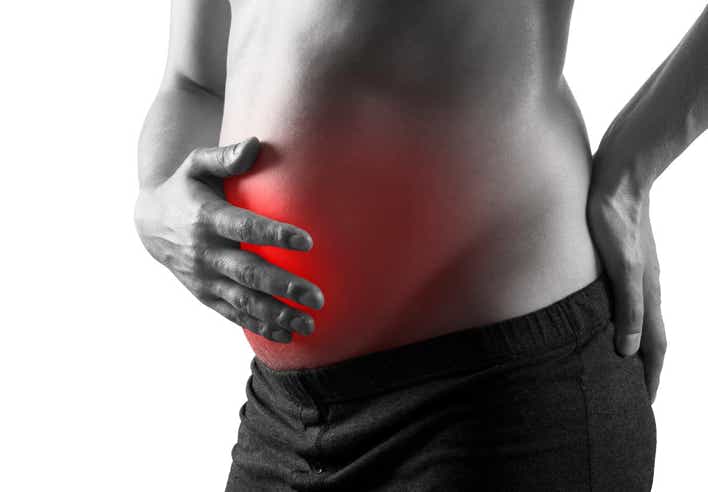 Image en noir et blanc d’un ventre gonflé mis en évidence par une zone rouge, symbolisant une gêne abdominale. Une main posée sur le ventre suggère une douleur liée aux ballonnements. Cette image illustre les bienfaits d’un massage contre les ballonnements pratiqué au cabinet Terre de Shiatsu Lyon 5e, destiné à soulager les tensions et améliorer le transit.