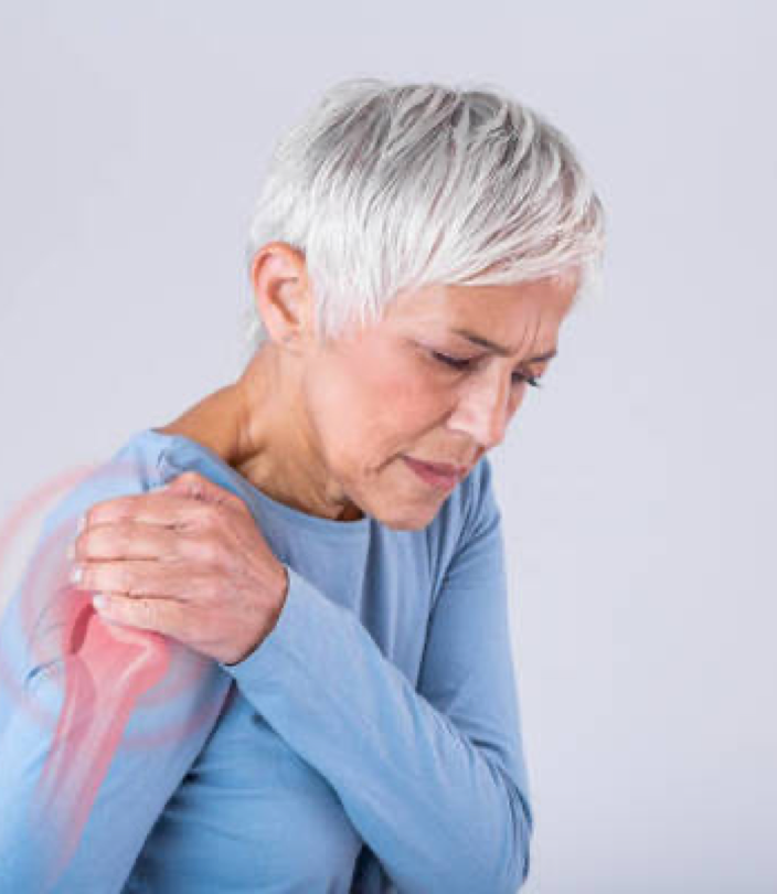 Femme senior touchant son épaule avec une expression de douleur, illustrant une inflammation articulaire ou une gêne musculaire, symbole des douleurs articulaires soulagées par le shiatsu - Cabinet Terre de Shiatsu Lyon 5e
