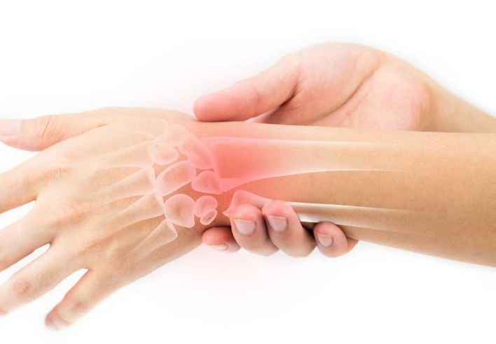 Illustration médicale d’une main tenant un poignet douloureux, avec surimpression des os et zone rouge pour indiquer l’inflammation articulaire, représentant les bienfaits du massage shiatsu pour soulager l’arthrose - cabinet Terre de Shiatsu Lyon 5e