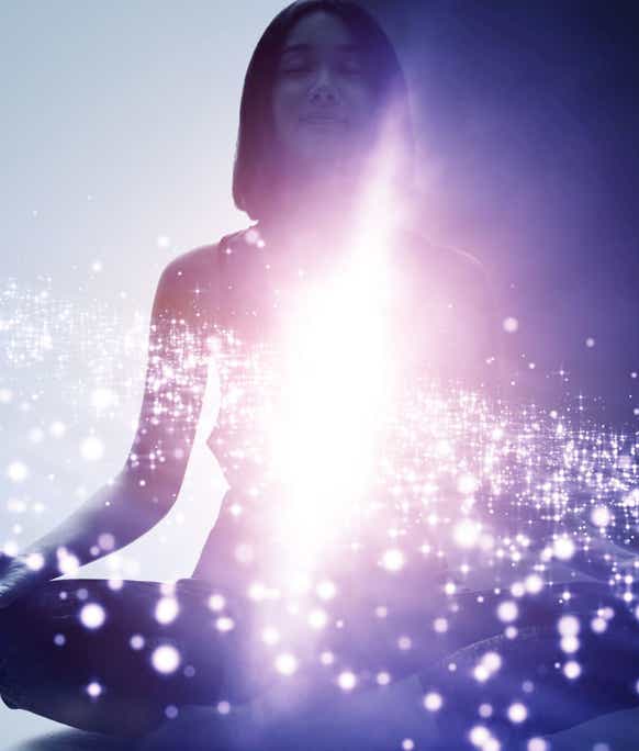 Une femme assise en position du lotus avec une lumière intense verticale autour de laquelle des points de lumière gravitent comme des étoiles autour d'une galaxie, symbolisant la transformation intérieure du massage métamorphique - cabinet Terre de Shiatsu Lyon 5e