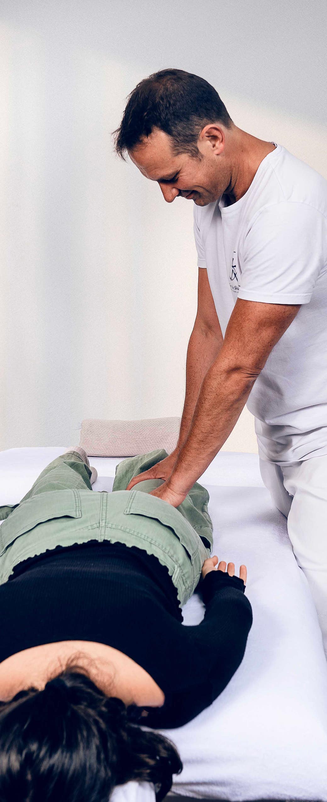 Jérôme Casadebaig pratique un soin de Shiatsu sur une patiente allongée, illustrant la disponibilité et le professionnalisme du cabinet Terre de Shiatsu Lyon 5e pour tout contact ou prise de rendez-vous.