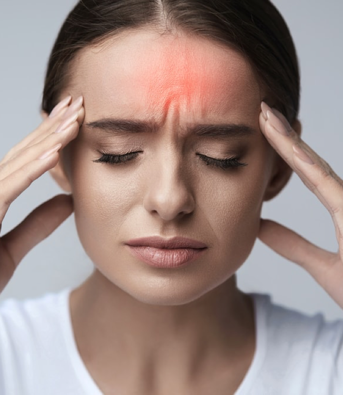 Femme souffrant de maux de tête, les mains posées sur les tempes, avec une zone rouge sur le front illustrant une migraine — soulagement des douleurs crâniennes par le Shiatsu - Cabinet Terre de Shiatsu Lyon 5e