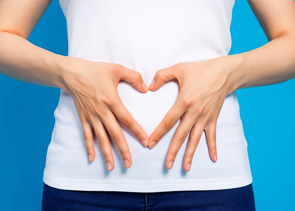 Une femme faisant un coeur avec ses mains sur son ventre pour illustrer les bienfaits du massage abdominal chi nei tsang - cabinet Terre de Shiatsu Lyon 5e