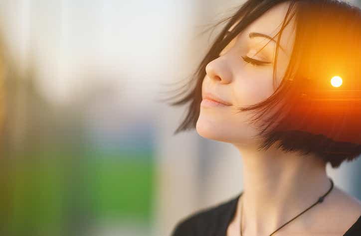 Jeune femme apaisée, les yeux fermés, avec un coucher de soleil dans la tête, symbolisant la détente mentale et l’équilibre émotionnel de la libération du péricarde au cabinet Terre de Shiatsu Lyon 5e