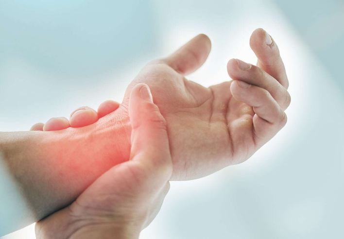 Main tenant un poignet douloureux avec une zone rouge indiquant une inflammation articulaire, illustrant l’effet du shiatsu sur les douleurs du poignet et de la main - cabinet Terre de Shiatsu Lyon 5e