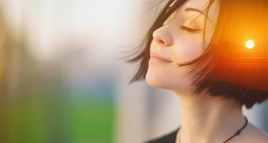 Jeune femme apaisée, les yeux fermés, avec un coucher de soleil dans la tête, symbolisant la détente mentale et l’équilibre émotionnel après un soin au cabinet Terre de Shiatsu Lyon 5e