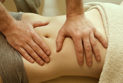 Massage Chi Nei Tsang pratiqué avec des pressions douces sur l'abdomen d'une patiente au cabinet Terre de Shiatsu Lyon
