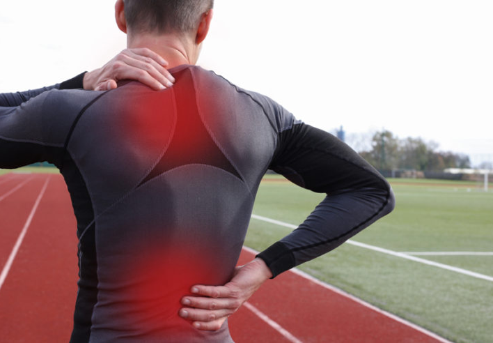 Homme de dos en tenue de sport tenant sa nuque et son bas du dos, avec des zones rouges indiquant des courbatures musculaires après effort physique - cabinet Terre de Shiatsu Lyon 5e