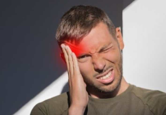 Homme souffrant de douleurs au niveau des tempes, illustrées par une lueur rouge sur la zone frontale. Cette image représente un cas de migraine soulagé par un massage front et tempes au cabinet Terre de Shiatsu Lyon 5e, utilisant des techniques d’acupression pour réduire le stress et détendre les tensions crâniennes.