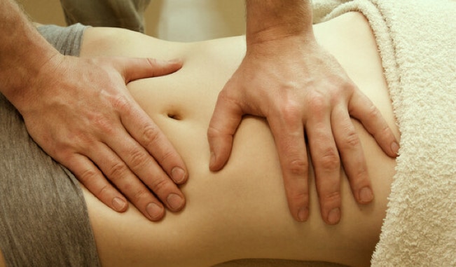 Massage chi nei tsang pratiqué avec des pressions douces sur l'abdomen d'une patiente au cabinet Terre de Shiatsu Lyon 5e