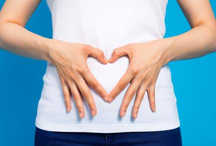 Femme faisant un coeur avec ses mains sur son ventre au cabinet terre de shiatsu Lyon 5e